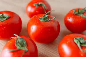 tomates rouges  pposées sur une table en bois 