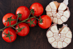 Tomates rouges en grappe et Ail coupés sur une table